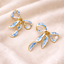 Aretes en forma de moño con pintas azules