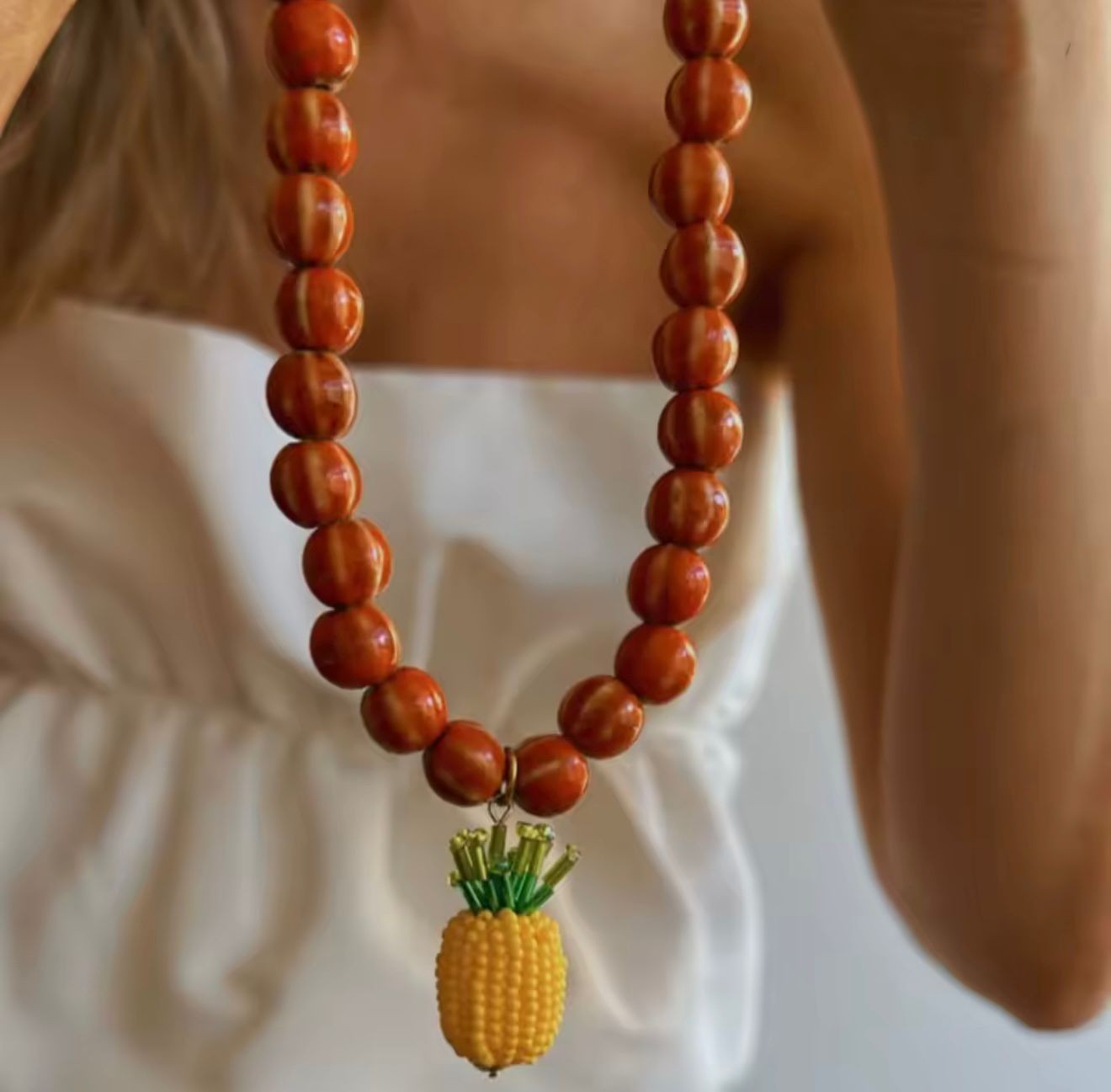 Collar de cuentas naranjas con dije de piña